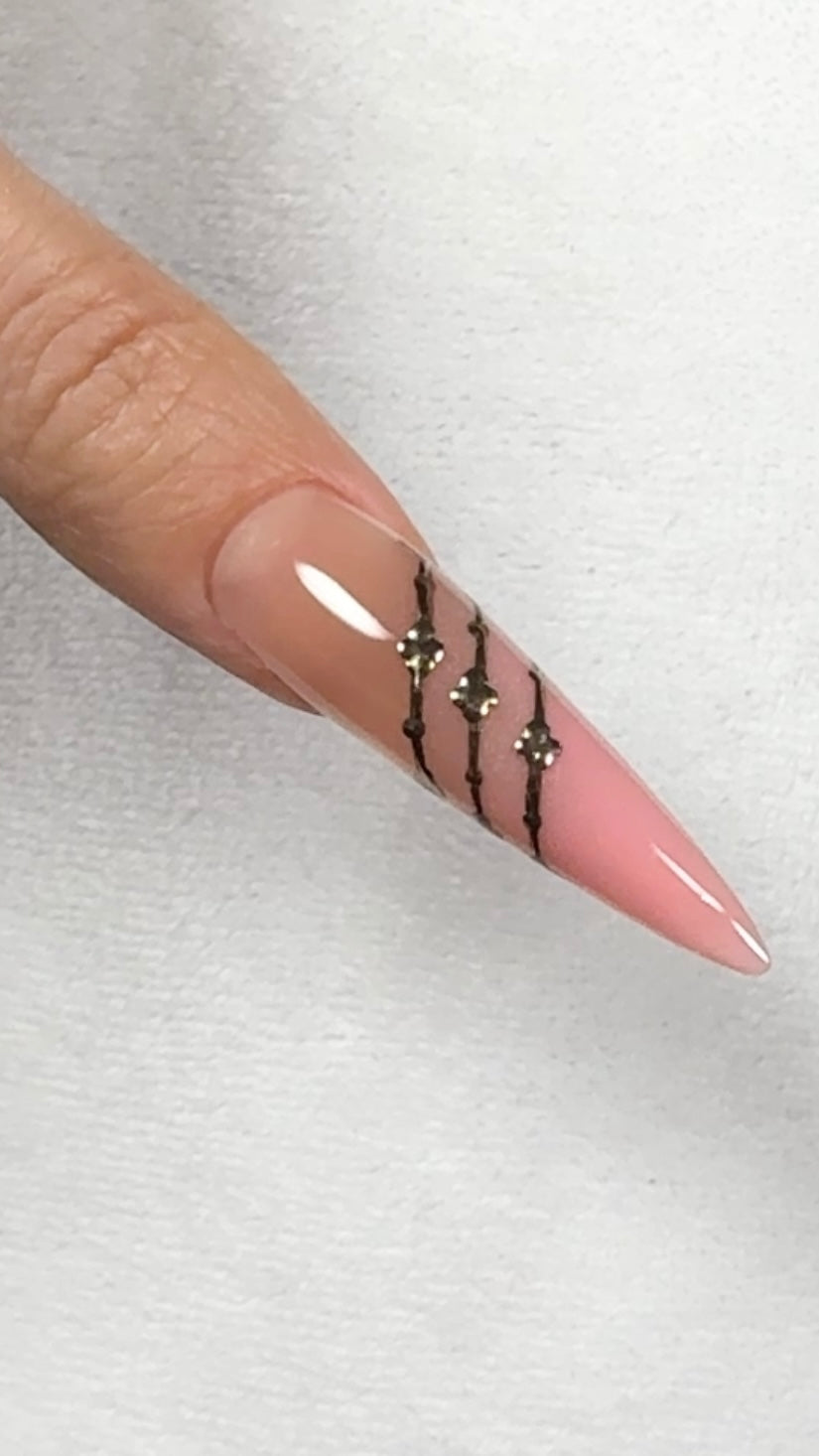 Nail with pink polish and black decorative elements on a white background